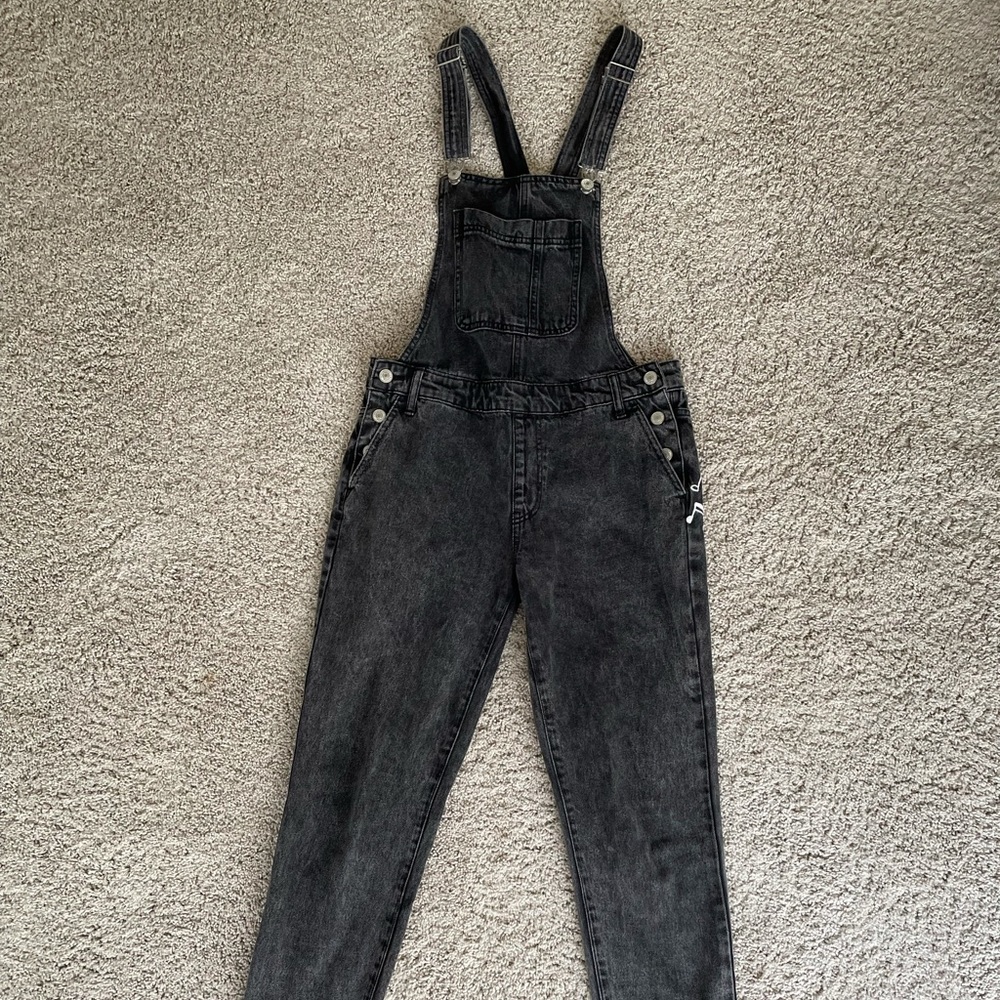 black overalls with music notes on the pockets